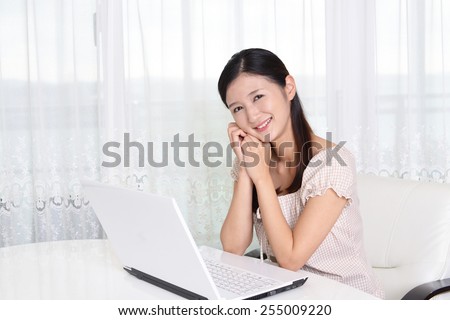 Smiling Asian woman with laptop computer