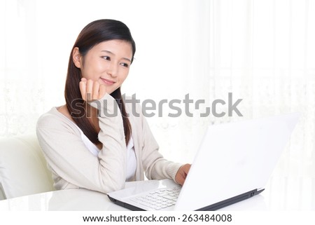 Smiling Asian woman with laptop computer