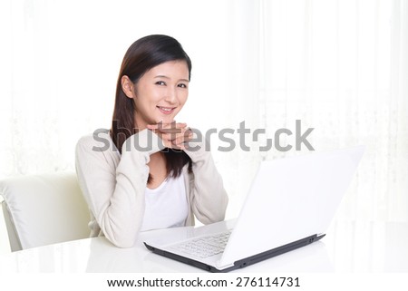 Smiling Asian woman with laptop