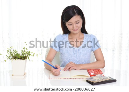 Smiling Asian housewife with money and calculator