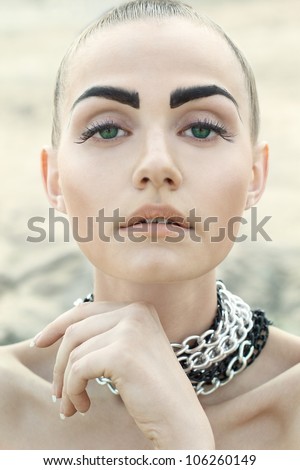 Fashion portrait of beautiful woman with chained neck posing on light full background