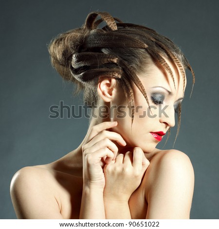 Fashion portrait of young beautiful woman with brunette fashion styled hair looking down