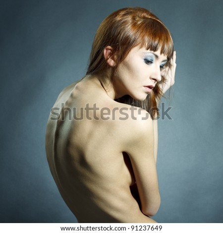 Fashion portrait of beautiful woman with elegant back posing on black background