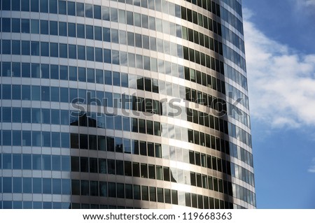 A modern building mirror facade illuminated by the sun