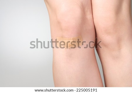 Female leg with adhesive bandage