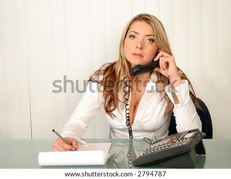 Young beautiful business woman in office holding phone and writing on note pad