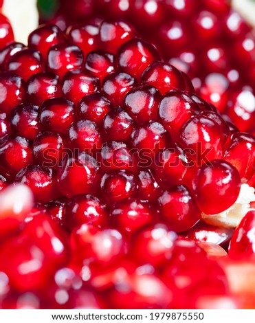 red and ripe pomegranate with juicy grains, delicious and healthy pomegranate divided into several parts, closeup fruit pomegranate