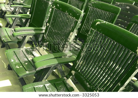 Plastic green beach chairs covered with sand