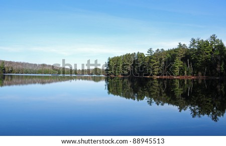 Pine Trees And Blue Sky Reflected In North Woods Lake, Wisconsin Stock ...