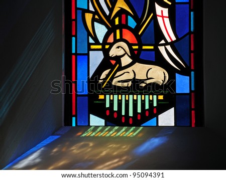 Stained glass window of Easter Lamb of God and reflection of window