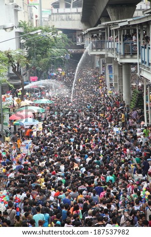 BANGKOK - APRIL 13: Stream of water over the crowd of people during celebrating the traditional Songkran New Year Festival, April 13, 2014, Silom road, Bangkok, Thailand.