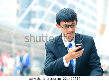 Man on smart phone - young business man. Casual urban professional businessman using smartphone smiling happy outside office building. Handsome man wearing suit outdoors.