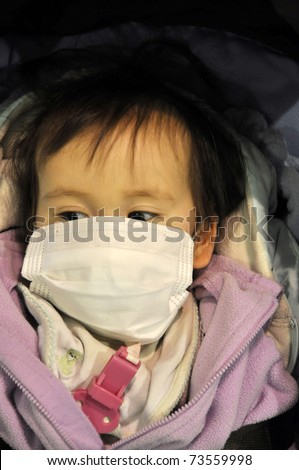 IBARAKI PREFECTURE, JAPAN-MAR 18:One year old Japanese girl Yuuna covered by a face mask protecting against radioactive dust in air after the Fukushima disaster Mar 18, 2011 in Ibaraki Prefect., Japan