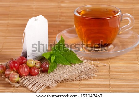 Fruit tea(tea package) in cup with gooseberry