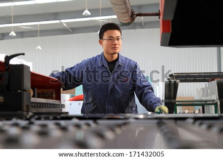 Luannan, November 24, 2012: A worker was operating CNC machine tools, in the DingRe Solar Energy Ltd, in November 24, 2012, Luannan County, china.