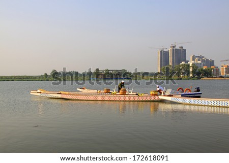 LUANNAN - JUNE 14: Several workers were putting in order dragon boats in water, in the North River Park on June 14, 2013, Luannan, Hebei Province, China.