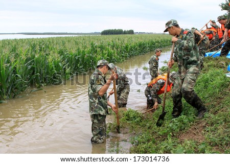 LUANNAN - AUGUST 4: Chinese armed police soldiers cleaning weeds control flood on August 4, 2012, Luannan, Hebei, China.