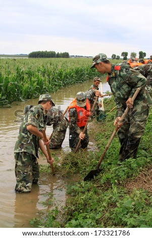 Luannan, August 4: Chinese armed police soldiers cleaning weeds control flood on August 4, 2012, Luannan, Hebei, China.