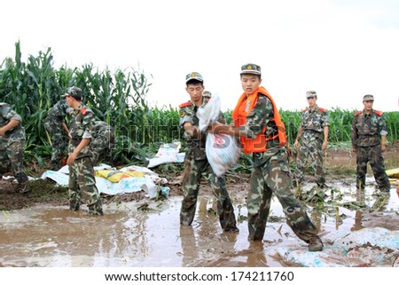 LUANNA, CHINA - AUG 4: Chinese armed police soldiers Stacked sandbags in flood danger area in Luanhe River levee small dam,  on August 4, 2012, Luannan, Hebei, China.
