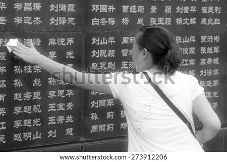 Tangshan City, July 28: A woman wipes the dust on the names of relatives died in the earthquake, before the Tangshan Earthquake Memorial Wall on July 28, 2012, Tangshan City, Hebei Province, China.