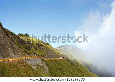 a beautiful day with cloud coming over the high mountain looking over one of the highest expressway (over 3000 meters)