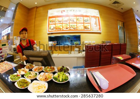 TAIPEI, TAIWAN - June 8: a girl serving at Beef Noodle in a Food court at a shopping mall on June 8, 2015, Taipei, Taiwan.  Beef Noodles is one of the many popular meal in Taiwan