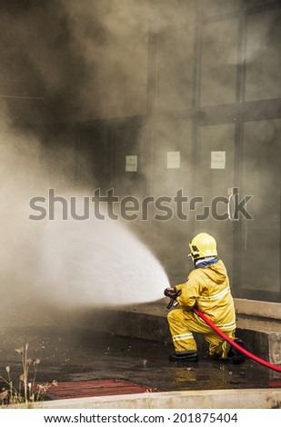Firefighter fighting a fire of a building . Cloud of smoke surrounding