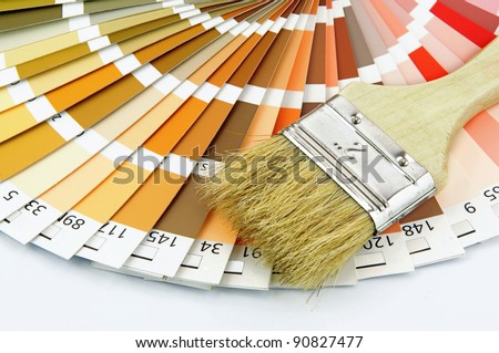 Paintbrush and wheel of colorful paint swatches.