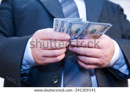 Businessman with money in hand recalculates dividends
