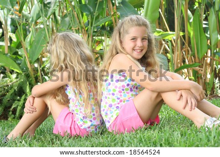 twin sisters outside in grass