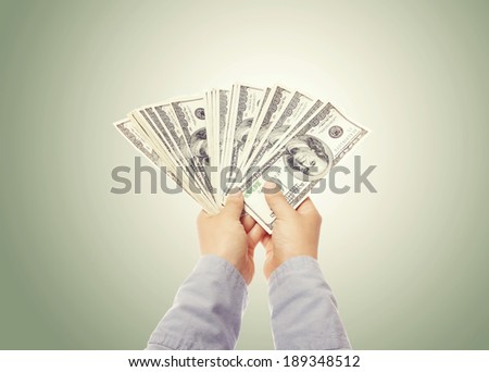 Hand displaying a spread of cash (US one hundred dollar bills)