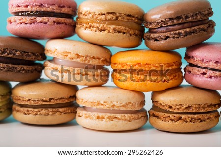 Stack of multi-colored macarons over pastel blue background