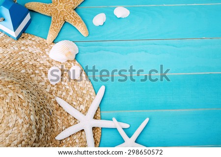 High Angle View of Beach Hat, Sea Shells and Starfish on Top of Light Cool Blue Table with Copy Space for Texts.