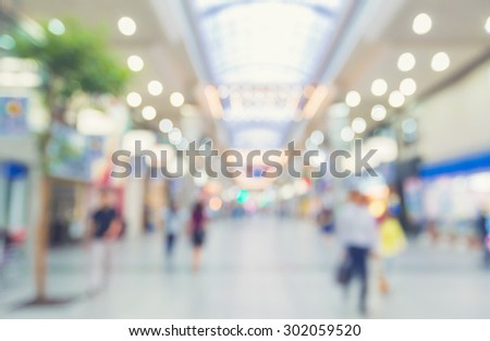 Defocused shopping mall interior with anonymous people walking