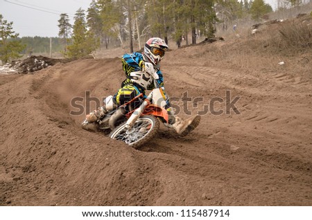 MX rider veering point-blank of sand with a large plume out from under the rear wheel, the Motocross practice