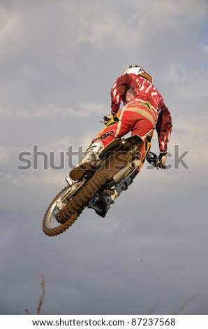 CHAPAYEVSK, SAMARA, RUSSIA  - OCTOBER 17: A spectacular jump from motocross racer I. Baranov on the background the Open Cup \