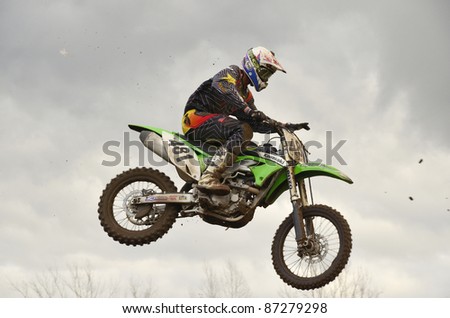 RUSSIA, SAMARA, CHAPAYEVSK - OCTOBER 17: The spectacular jump motocross racer S.Astaikin on the background a stormy sky the Open Cup \