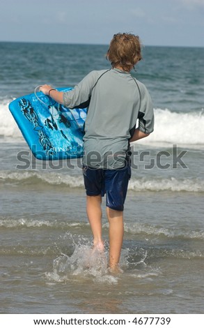 Young Boy at the Beach with Boogie Board