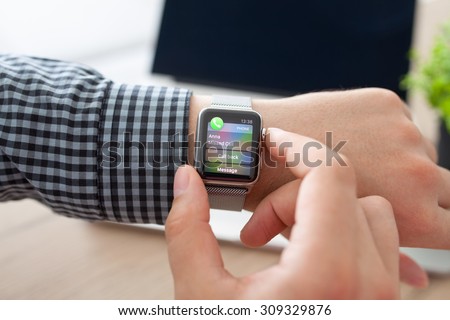 Alushta, Russia - August 11, 2015: Man hand with Apple Watch and missed phone call on the screen. Apple Watch was created and developed by the Apple inc.