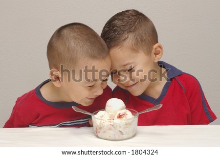 Two preschool brothers prepare to enjoy a large bowl of strawberry-cheesecake  ice cream