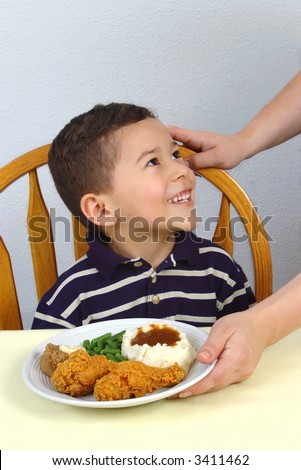 A young boy ready to eat his fried chicken dinner