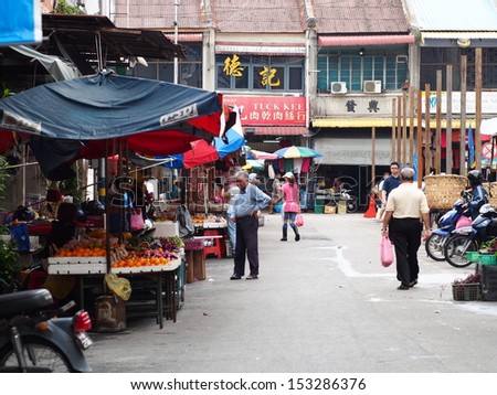 PENANG, MALAYSIA - APRIL 17: Shopper at a market fruit stall on April 17, 2013 in Air Itam, Penang, Malaysia. The market is at the foothill of South East Asia largest buddhist temple, Kek Lok Si.
