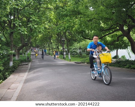 HANGZHOU, CHINA - MAY 23: Visitors visit the infamous West Lake on May 23, 2014 in Hangzhou, China. It was made a UNESCO World Heritage Site in 2011.