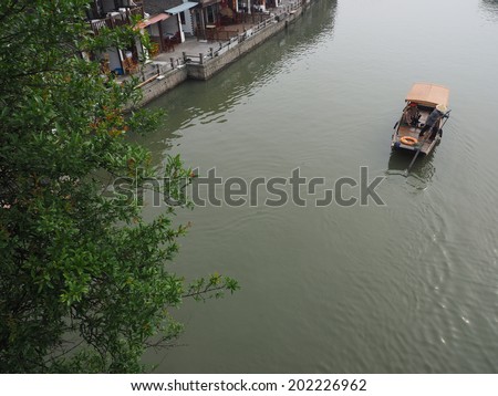 ZHUJIAJIAO, CHINA - MAY 21: Senior man transports recycling material in Chinese gondola on May 21, 2014 in Shanghai. Zhujiajiao is a well-known ancient water village  as Shanghai\'s version of Venice.