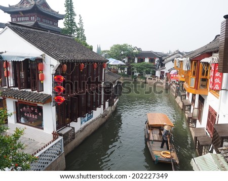 ZHUJIAJIAO, CHINA - MAY 21: Senior man transports recycling material in Chinese gondola on May 21, 2014 in Shanghai. Zhujiajiao is a well-known ancient water village  as Shanghai's version of Venice