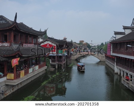 QIBAO, SHANGHAI - MAY 20: boats in the main canal and an old bridge on May 20, 2014 Qibao, Shanghai, China. Qibao water village is Shanghai tourist attraction with 1000000 visitors year.
