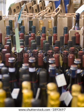 Rows of different types of wine are for sale in an open market in Northern Italy.