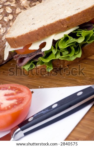 A fresh deli sandwich with tomatoes swiss chees, lettuce and lots of meat.