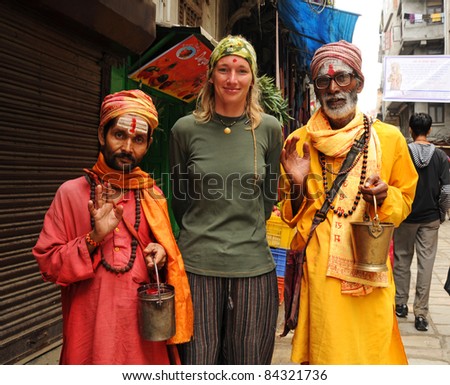 KATHMANDU, NEPAL - OCTOBER 1: Unidentified Nepalese holy men pose for picture with an European tourist on October 1, 2010 in Kathmandu, Nepal. The holy men pose for pictures in order to earn money.