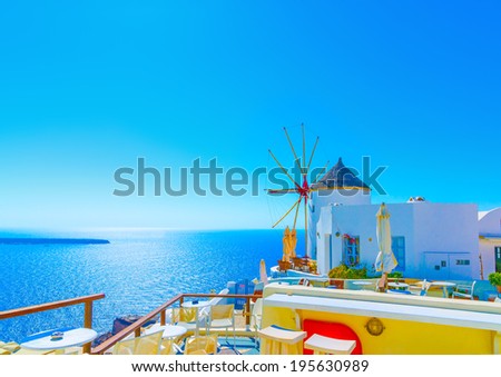 Amazing view to the sea including a pictorial old traditional windmill in Oia the most beautiful village of Santorini island in Greece